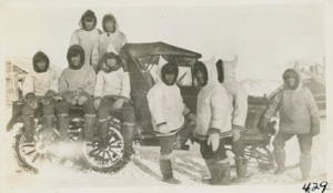 Image of Eskimos [Inuit] gathered around snowmobile donated by MacMillan [Ama Paniqniak in middle]